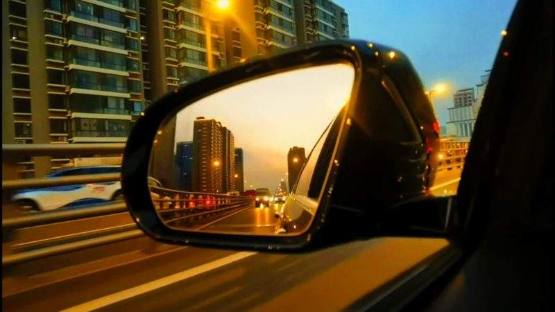 傍晚黄昏汽车行驶在城市中透过后视镜看街道视频素材模板下载-UI素材库